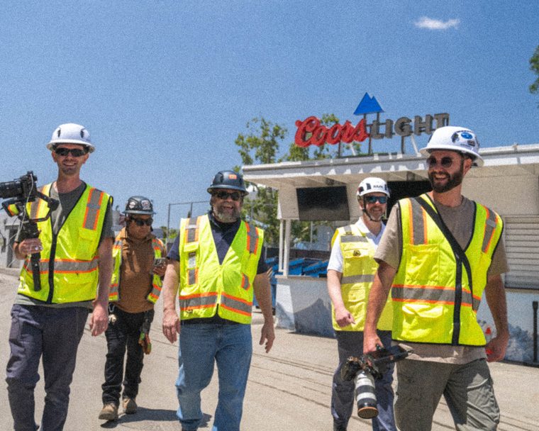 The CDS crew and the BrandSafway team walking the LA Coliseum site in hard hats and high-vis, camera rig in hand