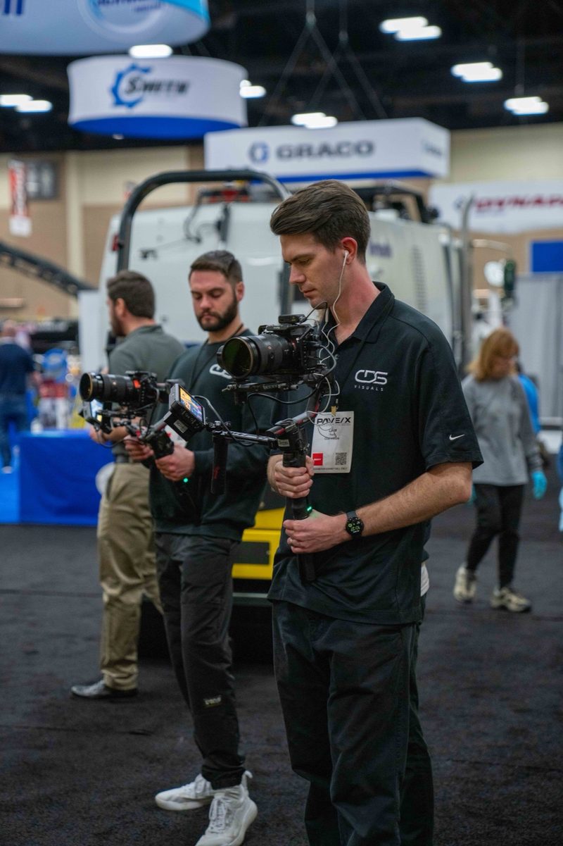 Two shooters moving through the show floor with cinema rigs