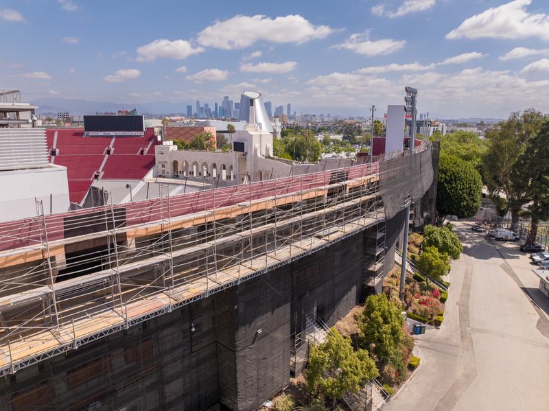 Scaffolding stacked along the stadium's outer wall, the LA skyline beyond