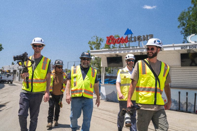 The crew walking out with camera gear, high-vis and hard hats on