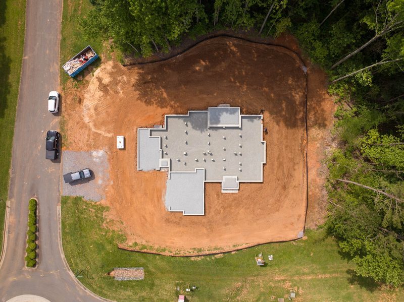 Straight down on the house pad, the cleared lot cut into the treeline