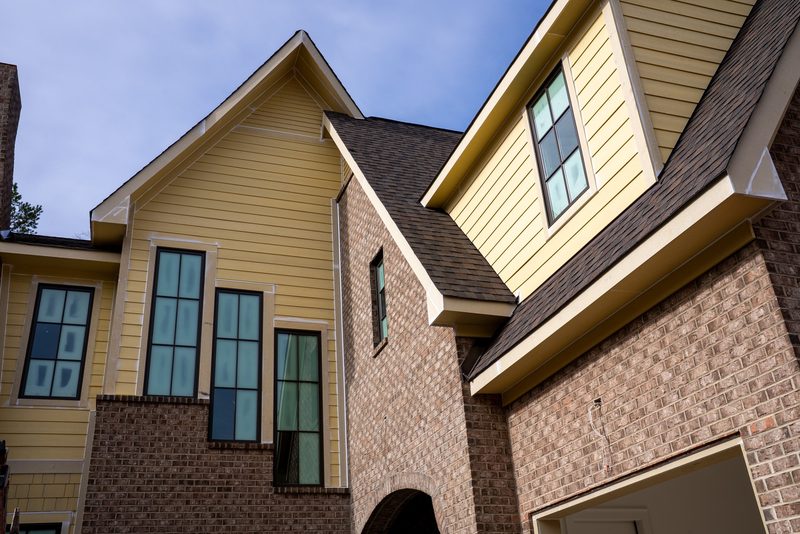 Looking up at the finished gables where siding meets brick