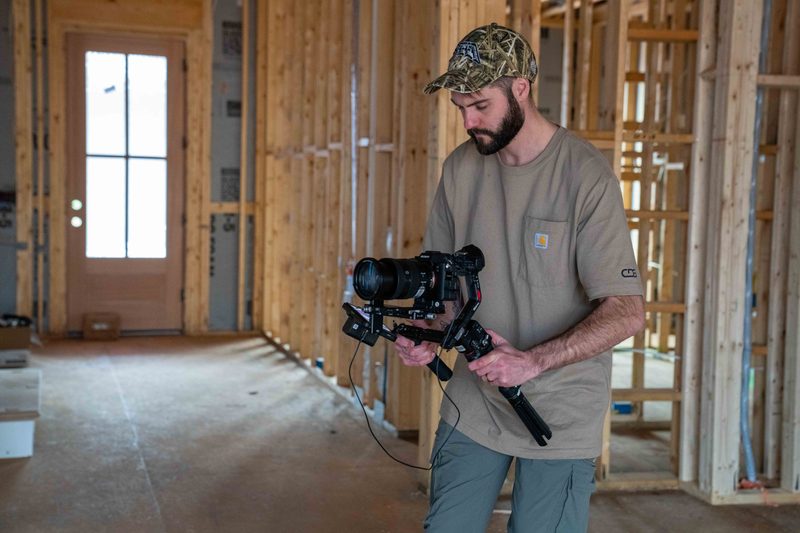 A shooter walking the framed interior with a gimbal rig