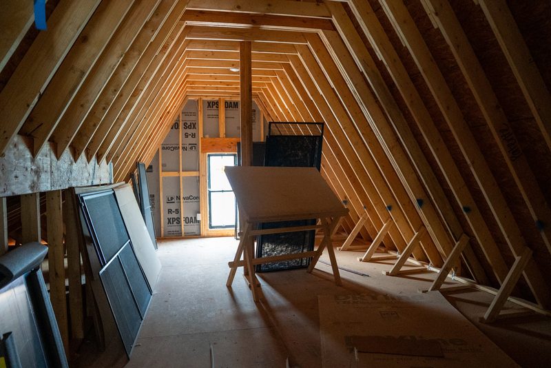 Inside the roof framing, rafters running away to the gable window