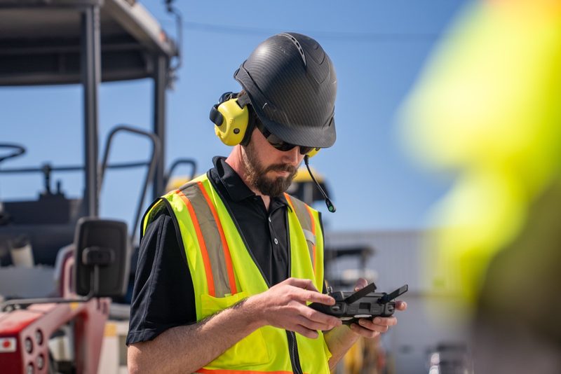 An operator in ear defenders running a machine on the remote box