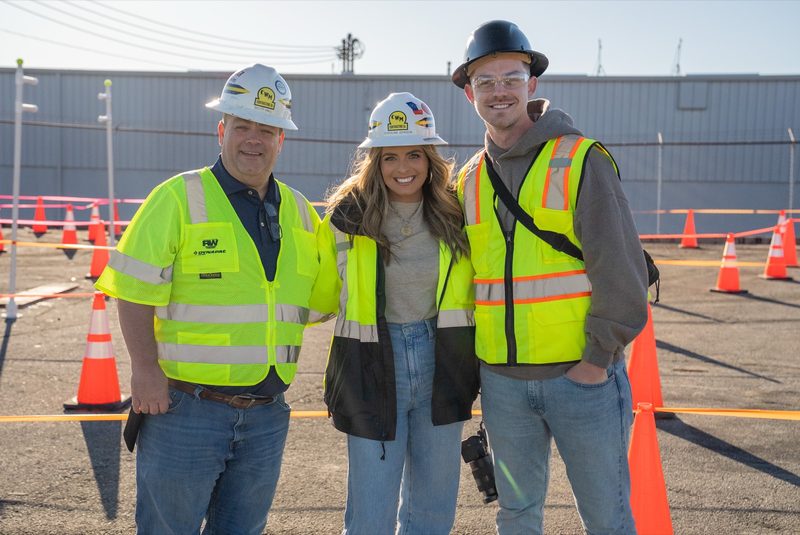 Three of the crew together on the lot, cones set out around them