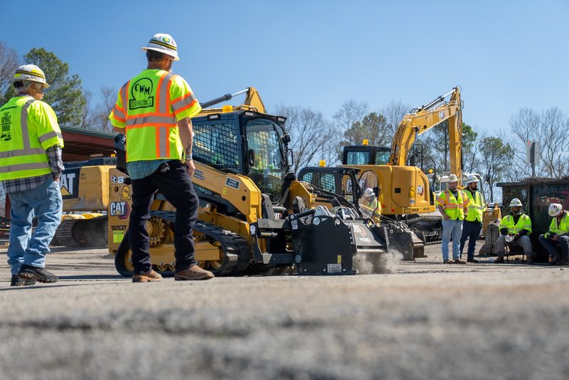 Crew watching the runs from behind a line of skid steers