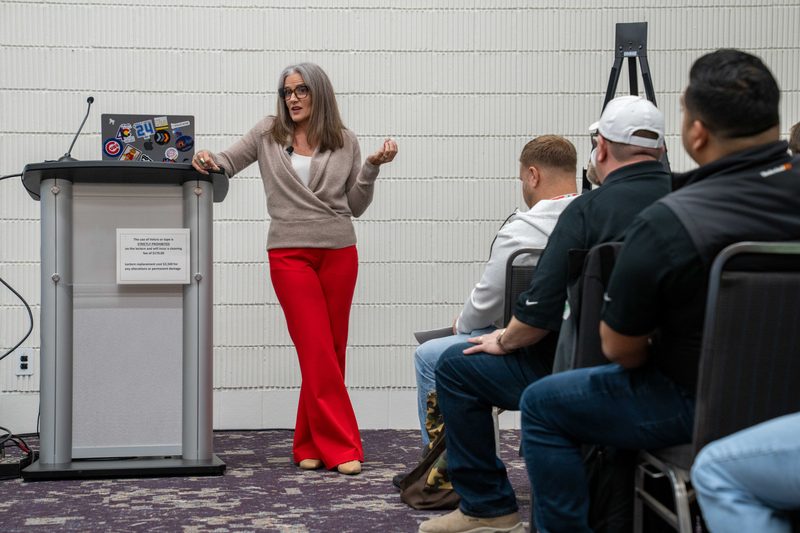 A speaker working the room from beside the lectern