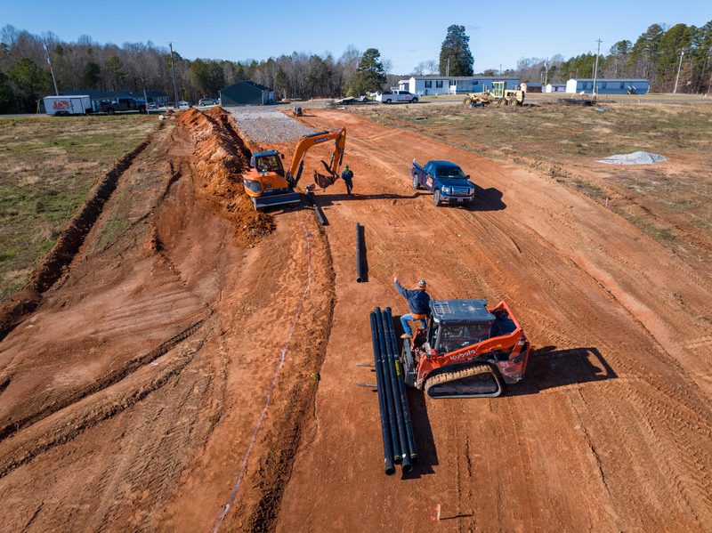 Aerial down the haul corridor, pipe staged along the cut