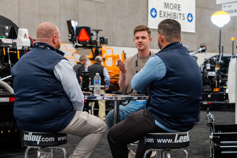 Three at the high table on the LeeBoy stand, mid-conversation