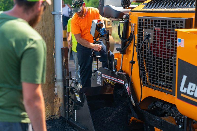 An operator climbing up to the controls on a LeeBoy machine