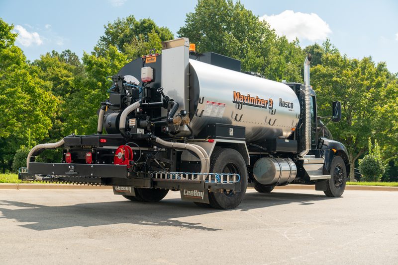 A Rosco Maximizer asphalt distributor running the road