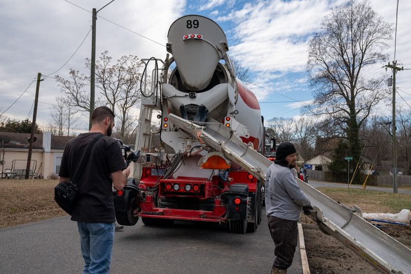 A shooter filming the mixer discharge from the roadside