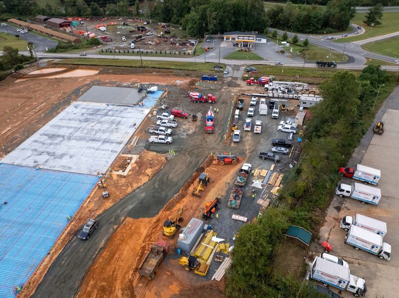 Aerial over the whole slab, trucks lined up along the barrier