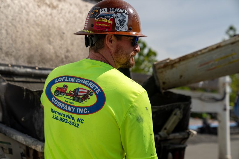 A crew member in a Loflin shirt working the chute