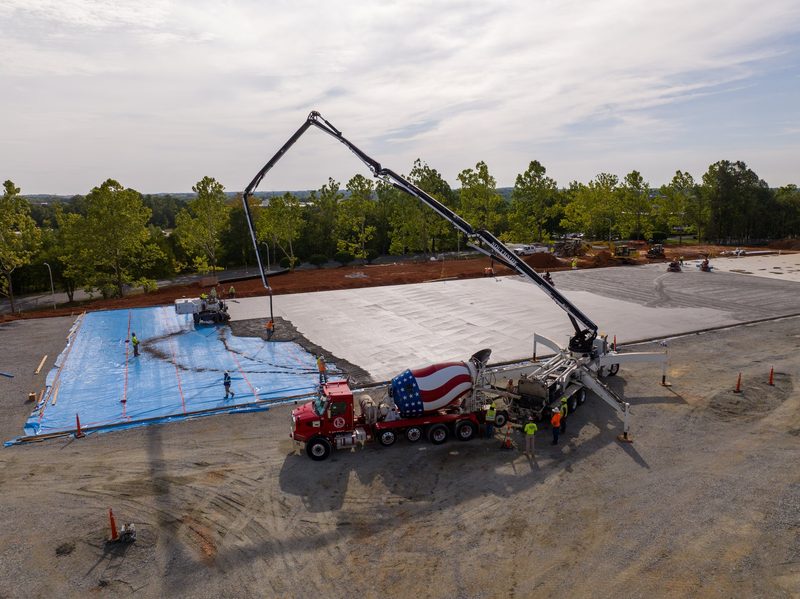 Aerial on the pour, the boom reaching across the blue sheeting
