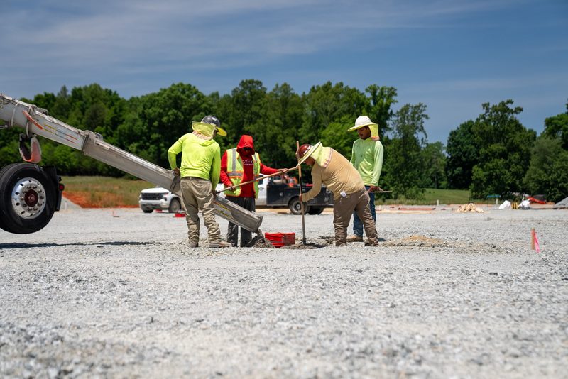 Crew working the chute across the gravel pad