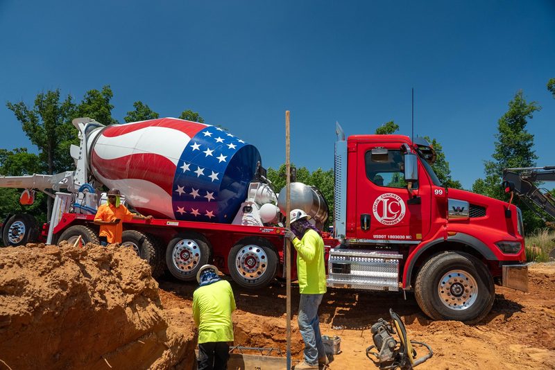 A Loflin mixer backed up to the footing, crew working the chute