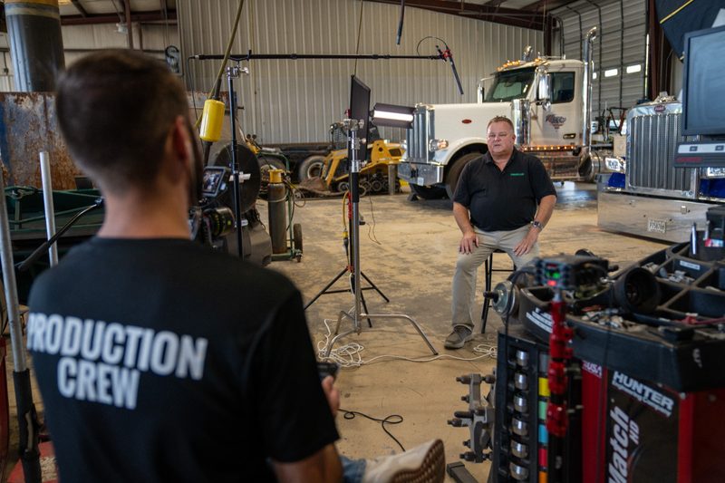 An interview set up in the shop, the subject lit against the trucks behind