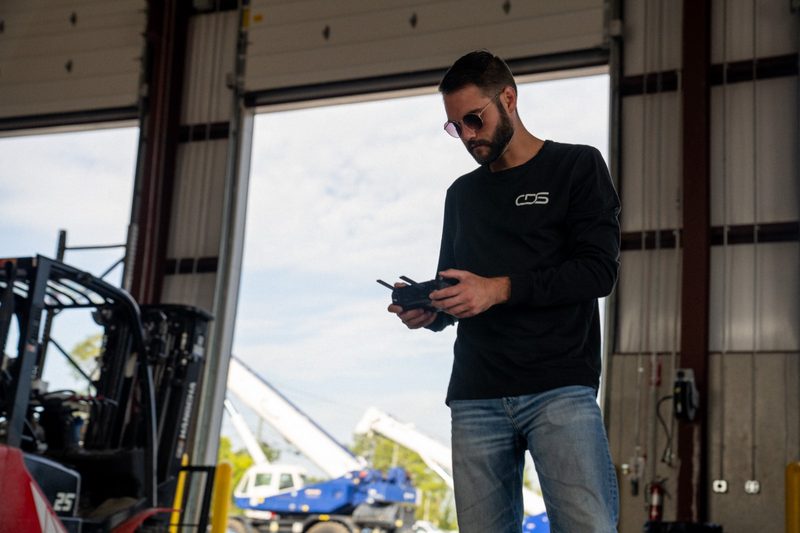 A crew member setting up the drone in the shop doorway