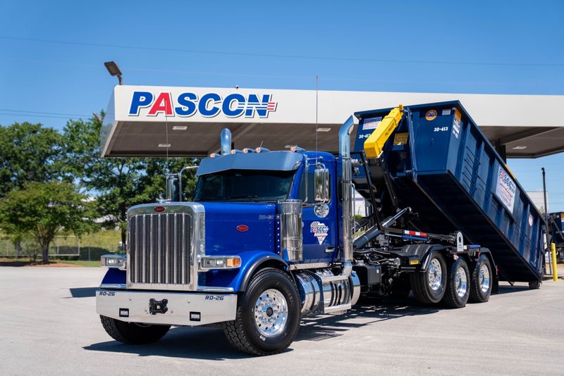 A Pascon roll-off truck parked in front of the shop