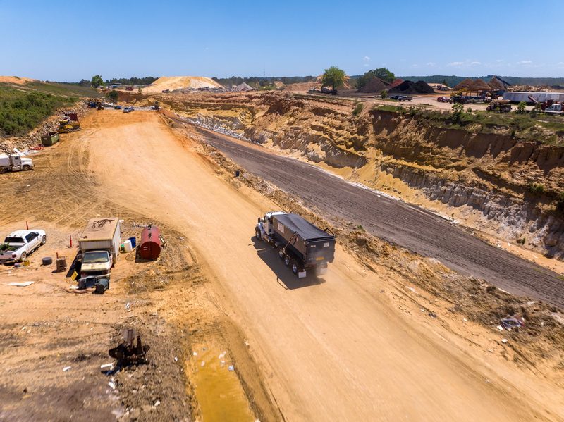 Aerial of a roll-off truck running the haul road at the landfill