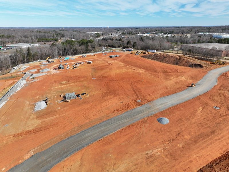 Aerial of the new road curving across the red clay pad