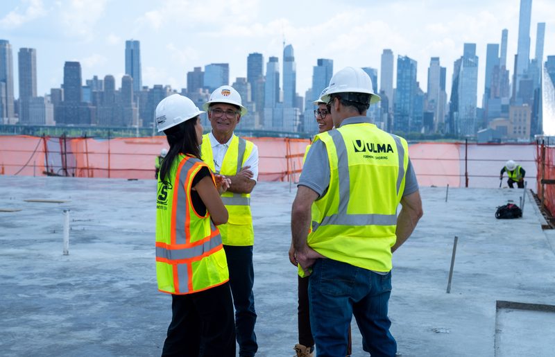 Three in high-vis on the finished deck, the skyline behind them