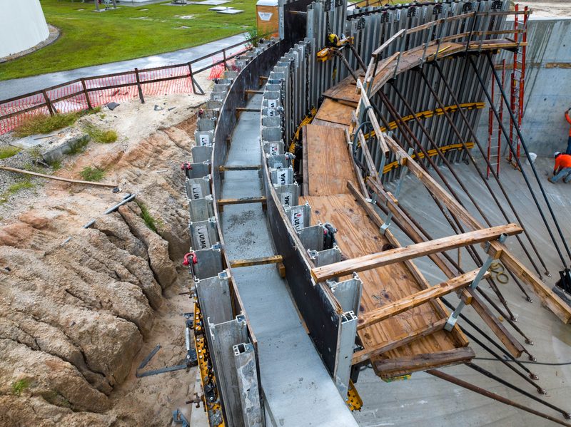 Aerial on the curved wall forms set against the rock face
