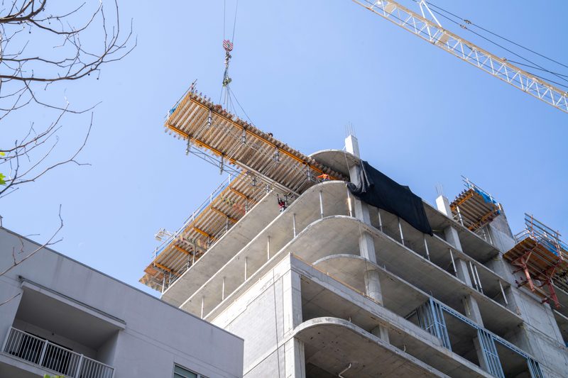 A crane lifting a formwork table up to the top deck