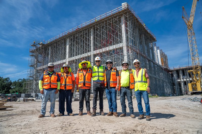 The crew lined up in front of the scaffolded structure they put up