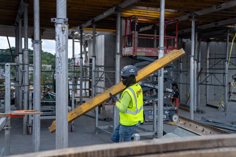 A worker carrying a joist out through the shoring