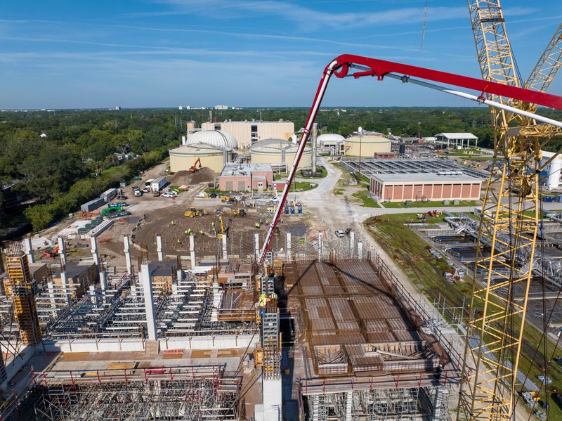 Aerial on the pour, the pump boom reaching out over the rebar