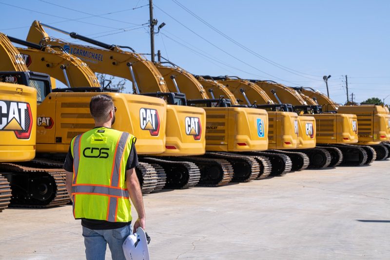 One of our crew walking the line of CAT excavators in the yard