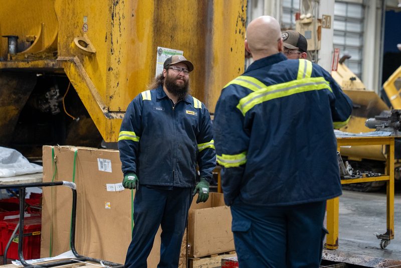 Two technicians talking through the job beside the machine