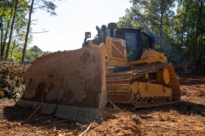 A CAT dozer pushing debris out of the clearing