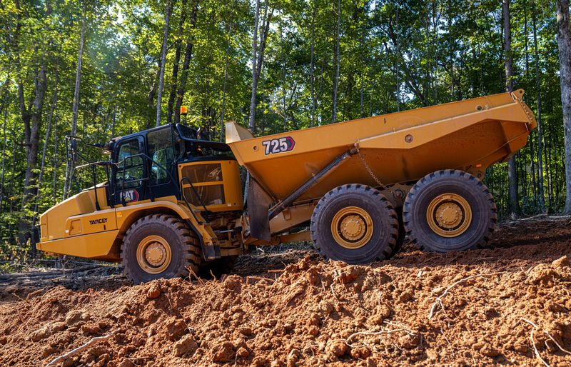 A CAT 725 articulated truck crossing the red dirt haul