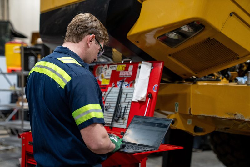 A technician running diagnostics from the laptop at the toolbox