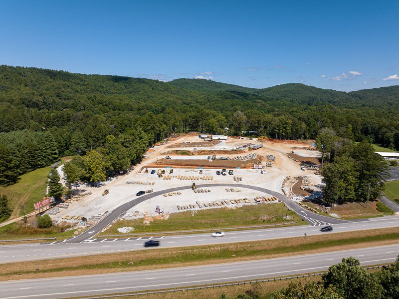 Aerial over the site going in beside the highway, ridgeline behind