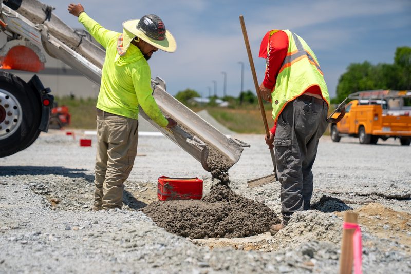 Two crew working the chute, concrete running into the form