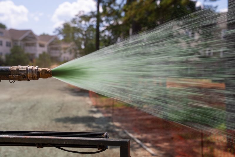 The spray gun mid-throw, the mulch plume jetting out in motion