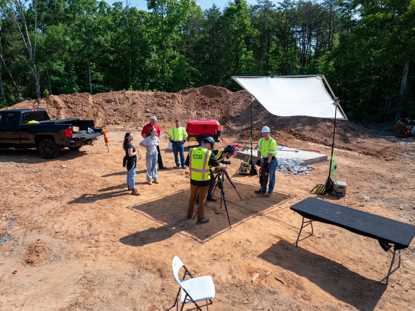 A CDS crew filming on a cleared site, camera on sticks under a diffusion frame
