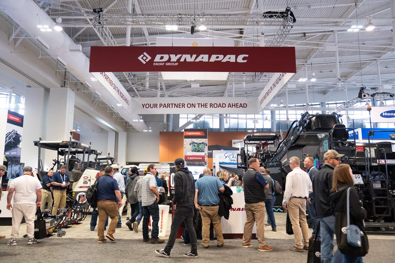 The Dynapac stand at World of Asphalt, machines and visitors under the banner