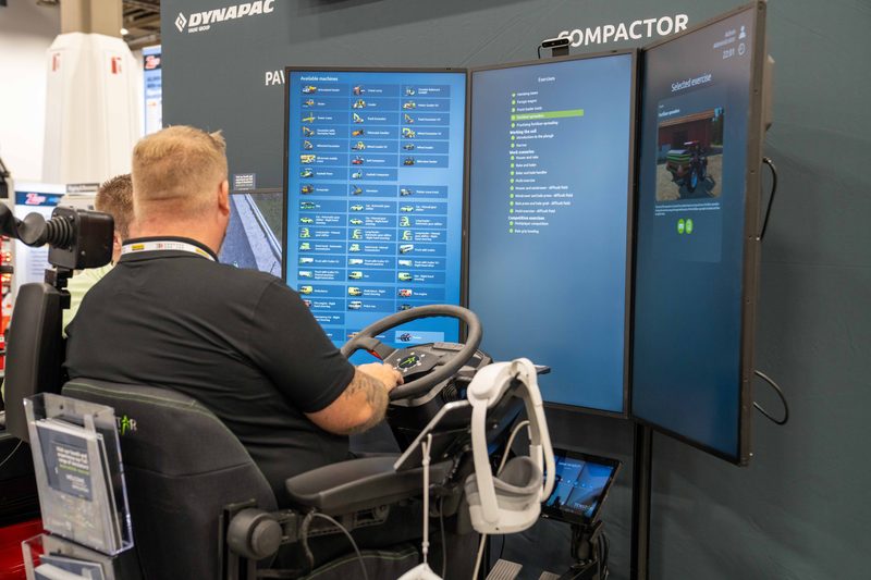 A visitor running the compactor simulator on the Dynapac stand at ConExpo